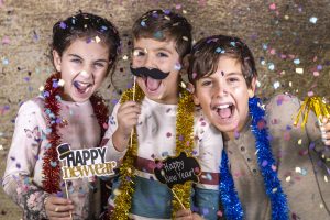 Thre happy kids celebrating new year eve at home